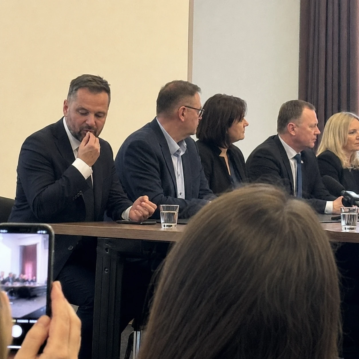 Osoba przy stole panelowym używa tabletki ODT podczas spotkania publicznego.